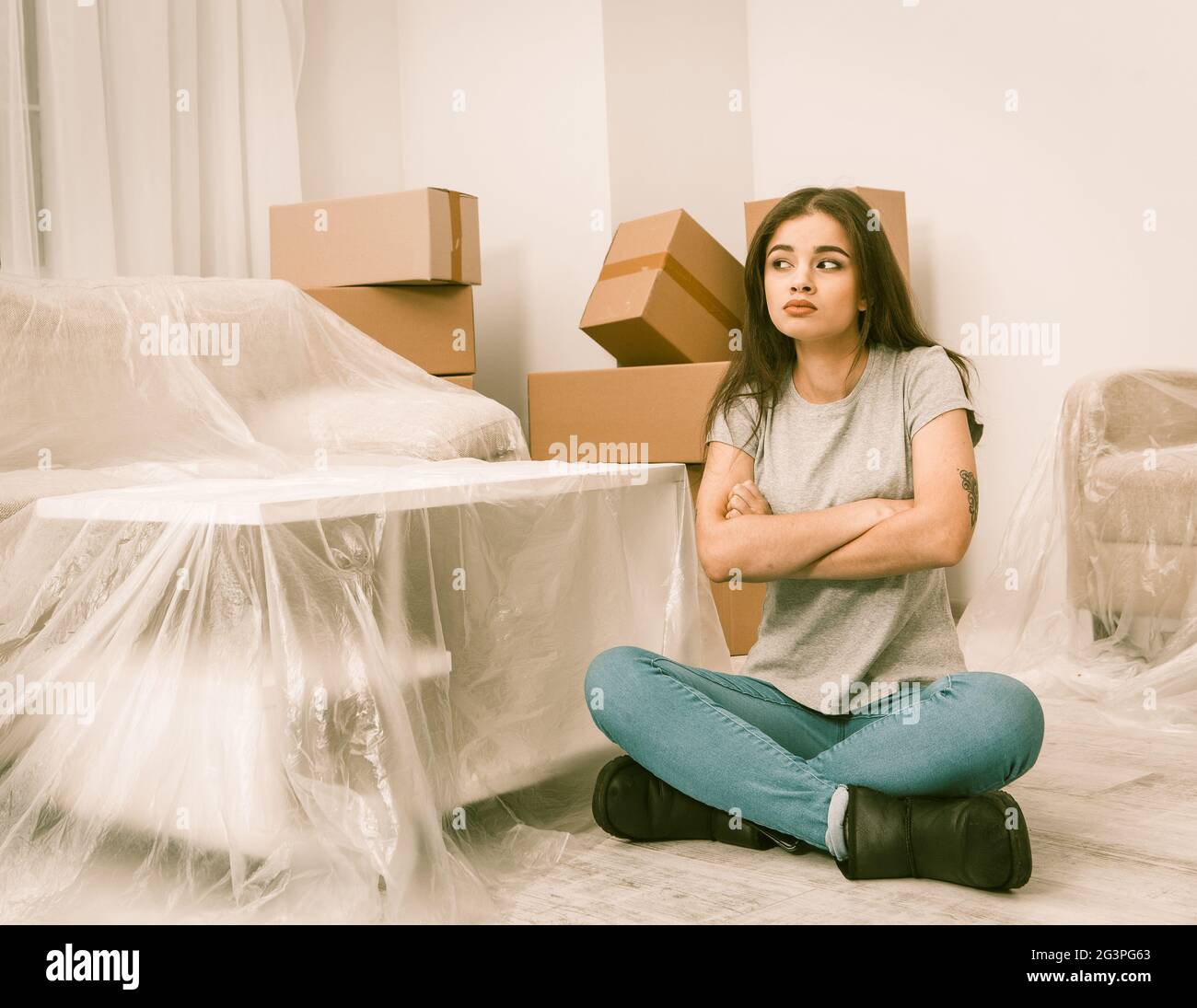 Brünette junge Frau, die versucht, geduldig zu sein, beim Umzug in neue Wohnung. Stockfoto