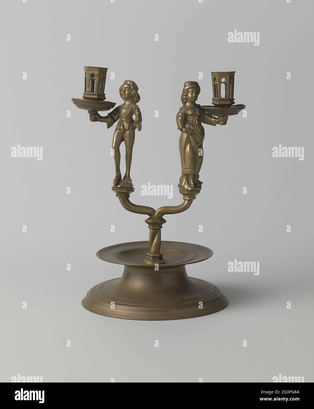 Zweiarmiger Kerzenständer mit einer Männer- und einer Frauenfigur. Der  Kerzenständer besteht aus den folgenden acht Teilen, von denen nur die  ersten beiden abnehmbar sind: Dem Fuß, dem Stamm, den beiden Figuren, den