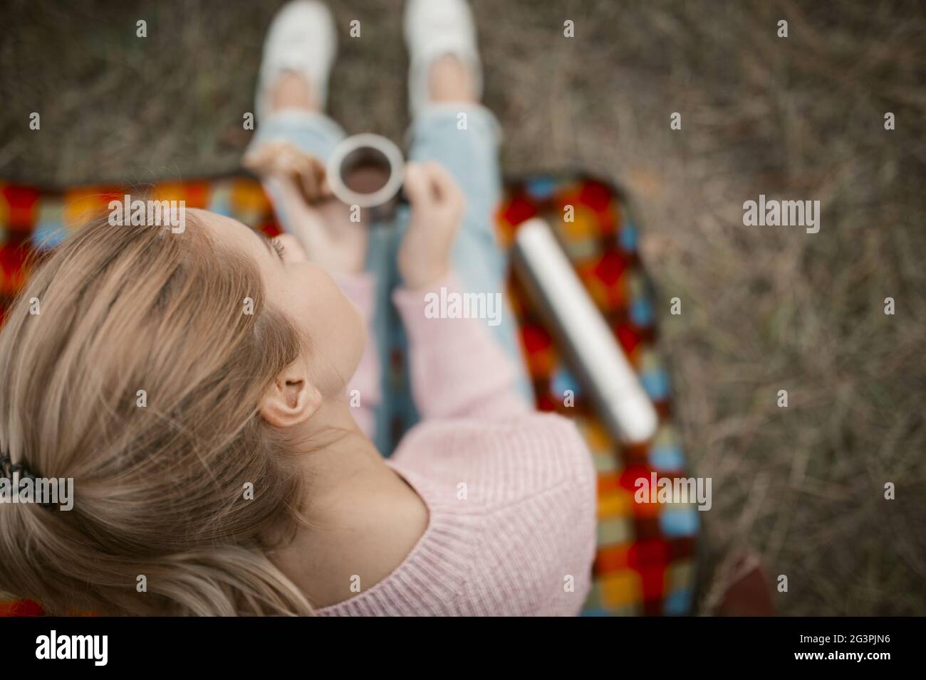 Blonde Frau Mit Heißgetränk Auf Picknick In Der Natur Stockfoto