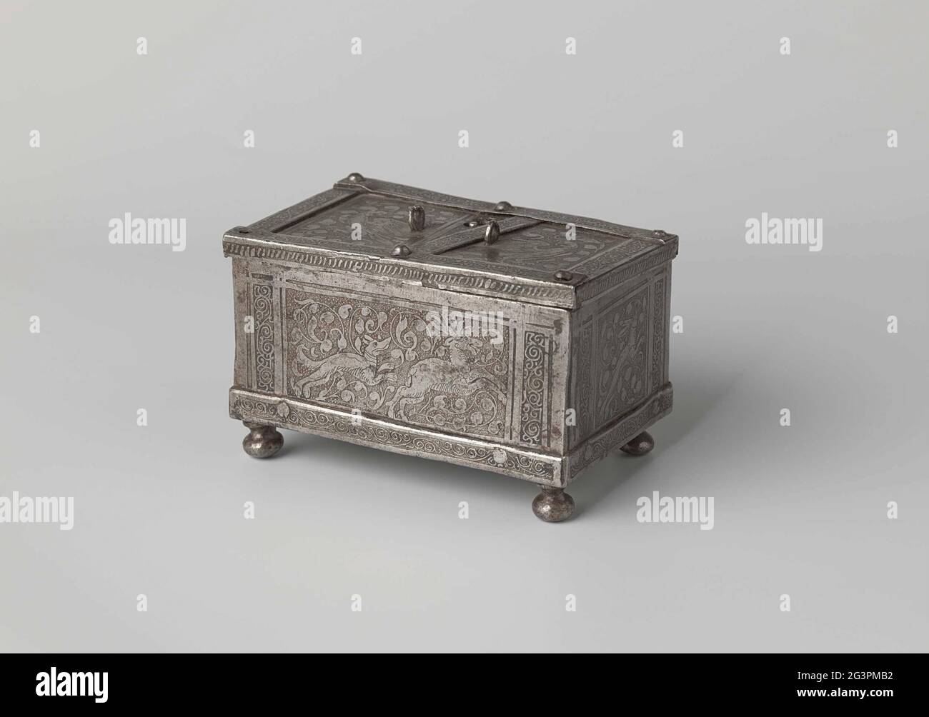 Schmuckkachtel aus Schmiedeeisen, verziert mit Tieren in einem Spankpiece. Eine geschmiedete Eisenkaste auf vier kugelförmigen Beinen. Alle Seiten sind poliert und geätzt, Tiere mitten in der Flut in Listen mit arabisch dekoriert. Auf dem für einen Hund, der ein Reh gejagt hat, jagt ein Hund einen Fuchs auf dem Rücken. Auf den zwei kurzen ein Hund und ein Hase. Auf dem Deckel zwei Vögel in der Mitte eines Bereichs. Die Ränder und der Boden sind mit Arabesken verziert. Auf zwei gewaschenen Ringen, um den Griff zu befestigen. Dazwischen ein lockerer Reifen, der verschoben werden kann, einschließlich des Schlüssellochs. Stockfoto