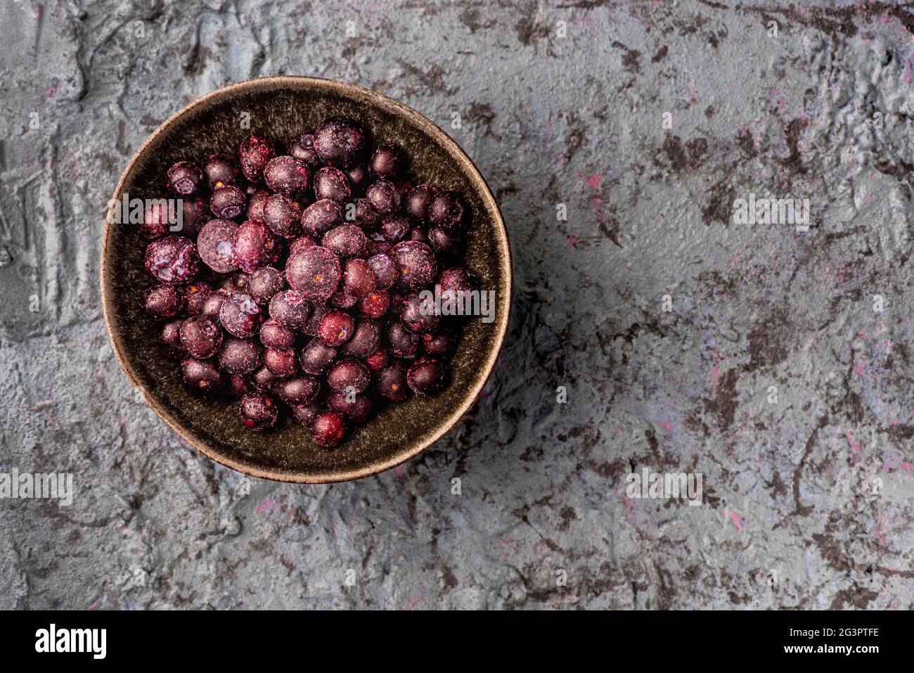 Schüssel mit gefrorenen Blaubeeren auf strukturierter Oberfläche Stockfoto