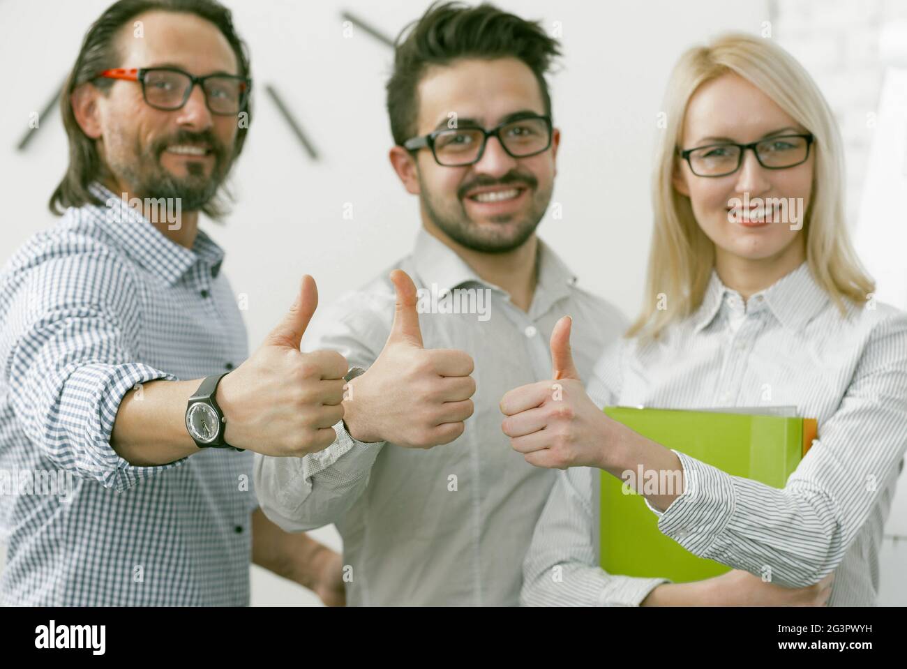 Geschäftsteam zeigt Daumen nach oben. Büroangestellte, die eine positive Stimmung ausdrücken, zeigen ein Daumen-hoch-Zeichen, das alles bedeutet Stockfoto