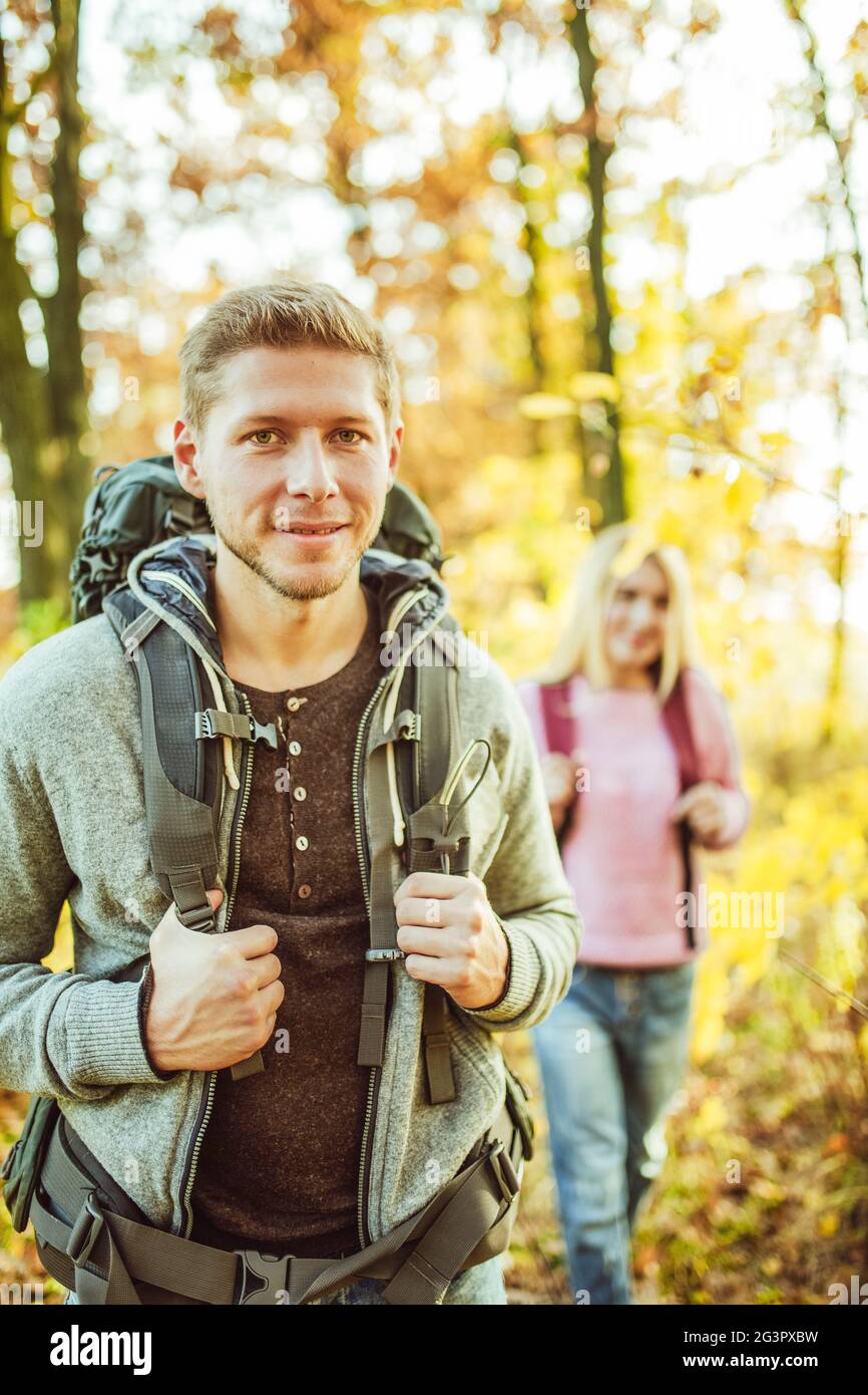 Zwei Rucksacktouristen in der herbstlichen Natur, fröhliches Paar, kaukasischer Mann und Frau machen sich auf den Weg zu neuen Abenteuern, Reise in die Natur Stockfoto