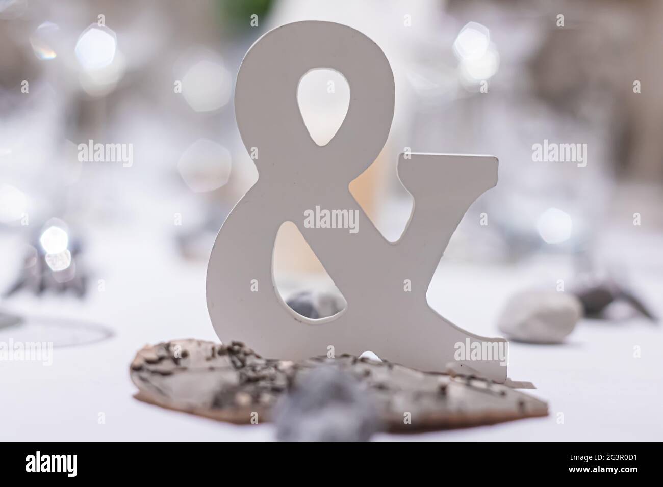 Dreidimensional hell Ampersand Zeichen auf einem weißen gedeckten Tisch eine Hochzeitsfeier Stockfoto