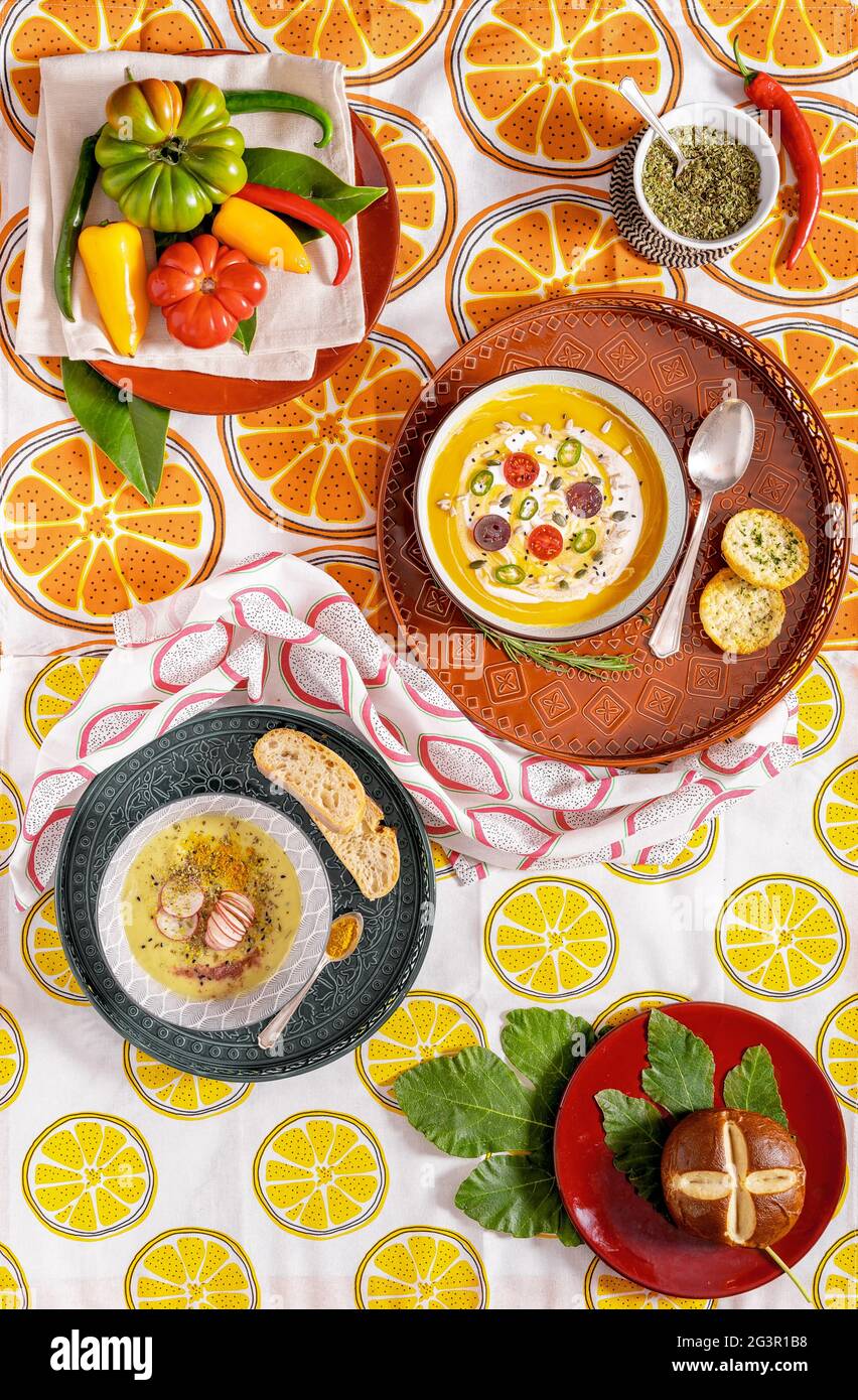 Flache Lay-Fotografie einer veganen Kürbiscremesuppe und Brot. Gemüserezept. Draufsicht auf ein Püree aus saisonalen Produkten mit Gewürzen und Retro-Patte Stockfoto