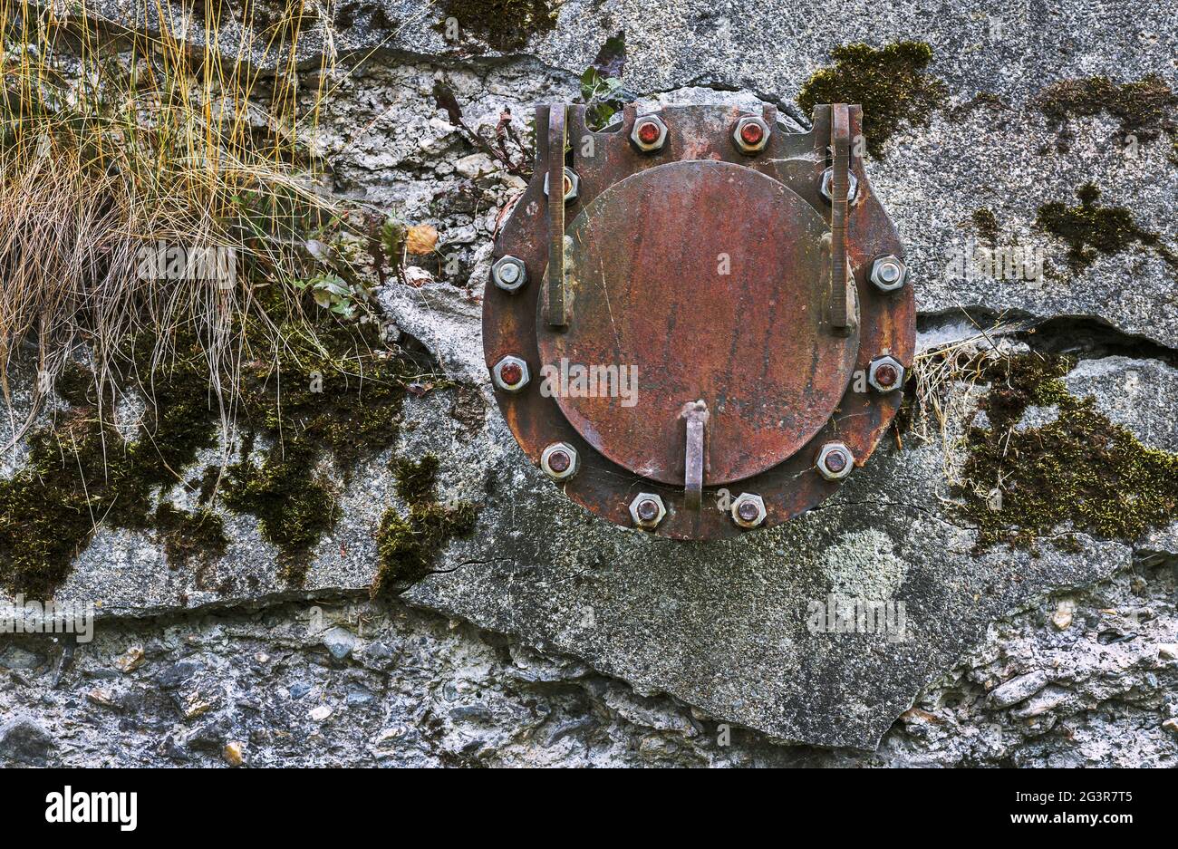 Der Flansch an der alten Wand Stockfoto