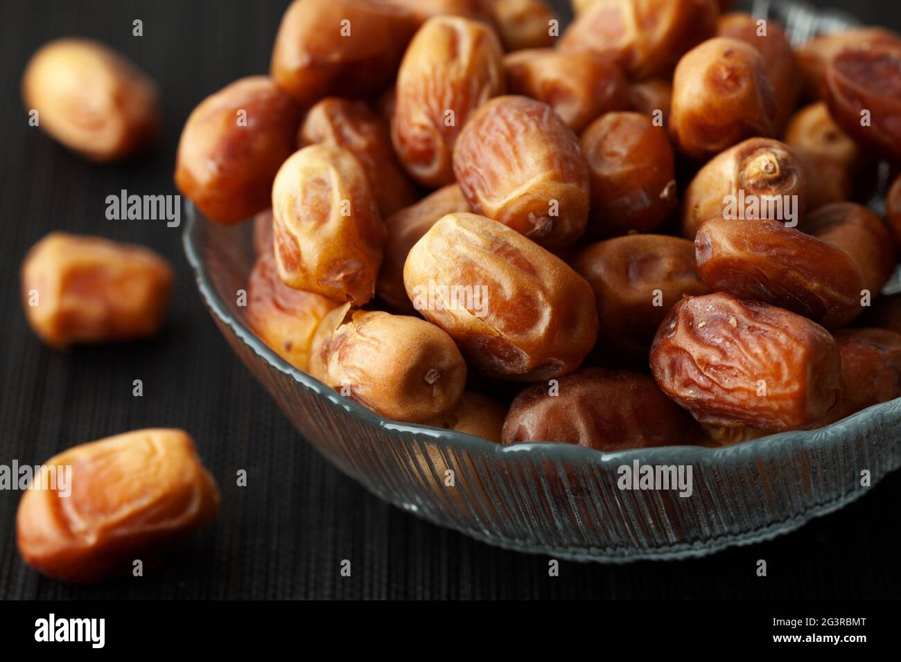 Getrocknete Datteln in einer Glasschüssel. Low-Taste. Nahaufnahme. Stockfoto