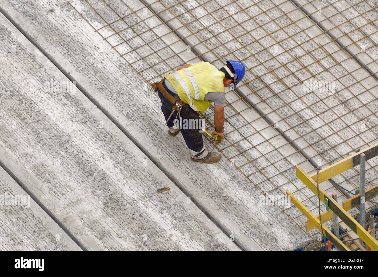 Arbeiter auf einer Baustelle (Gebäude), der die Betonbewehrung auf dem Fundament eines Gebäudes anpasst Stockfoto