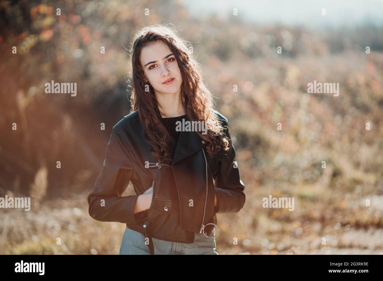 Outdoor-Porträt eines schönen Teenager Brünette Mädchen in der schwarzen Lederjacke Stockfoto