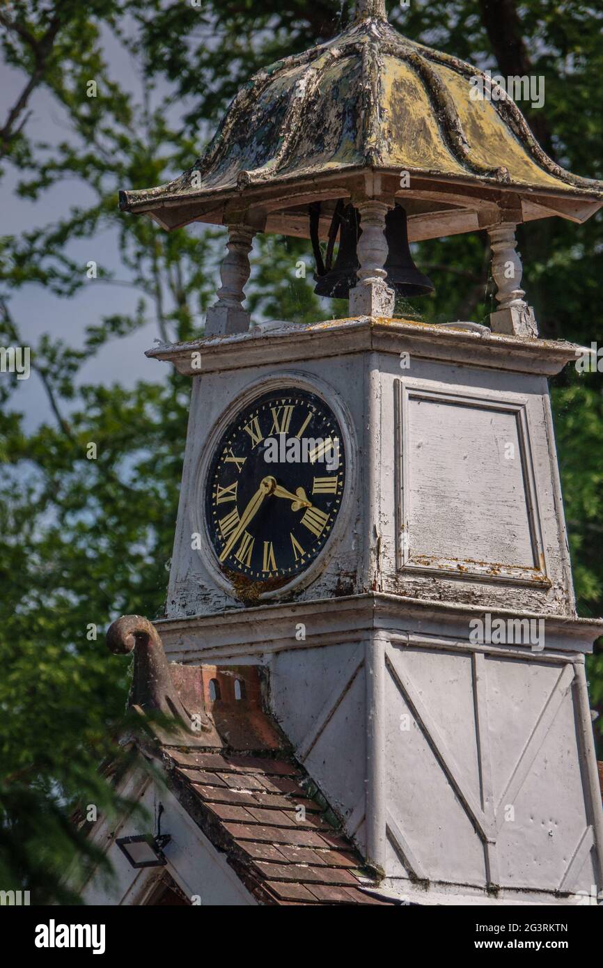 Eine Uhr und ein Glockenturm auf einem rot gefliesten Dach in Wiltshire Stockfoto