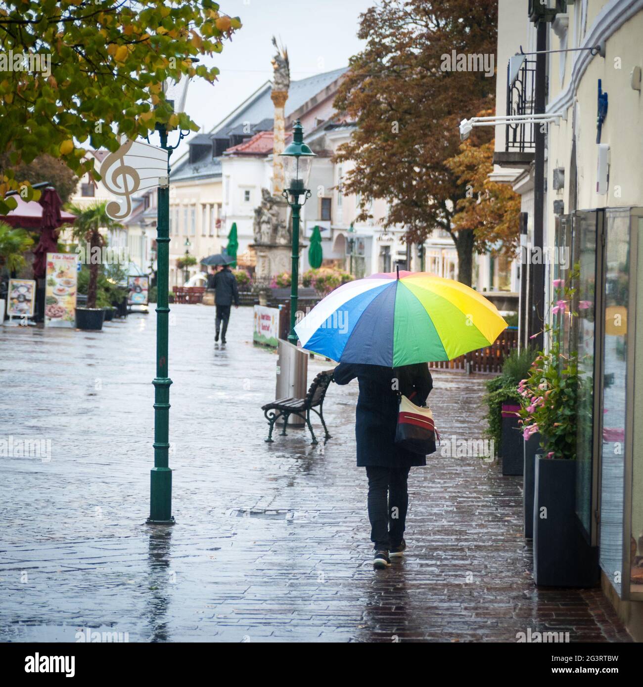 Einkaufen bei Regenwetter mit einem Regenschirm Stockfoto