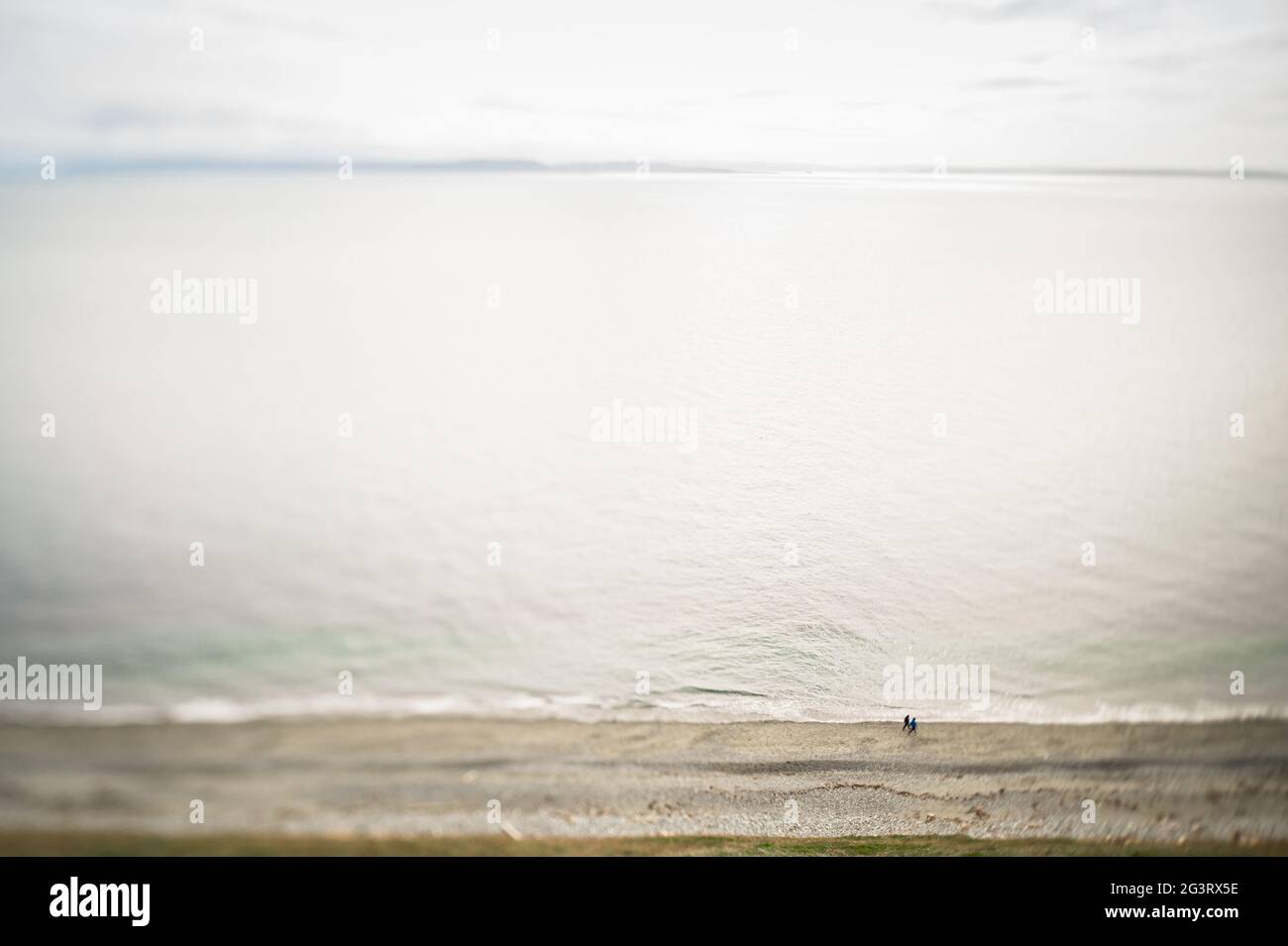High Angle Blick auf das Meer mit zwei Personen zu Fuß am Strand Stockfoto