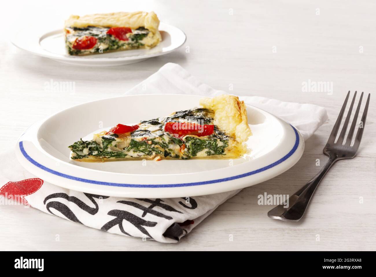 Hausgemachte Spinat-Quiche auf dem Teller. Stockfoto