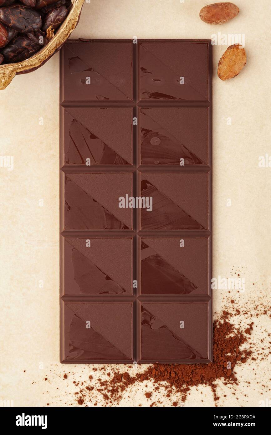 Schokoladenriegel Hintergrund mit Kakaopulver und ganzen Bohnen. Stockfoto