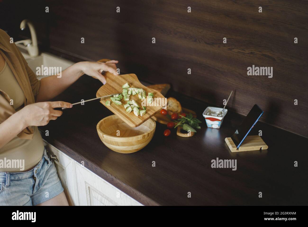 Weitwinkel der Frau gießen auf Avocado Stücke in die Schüssel Stockfoto