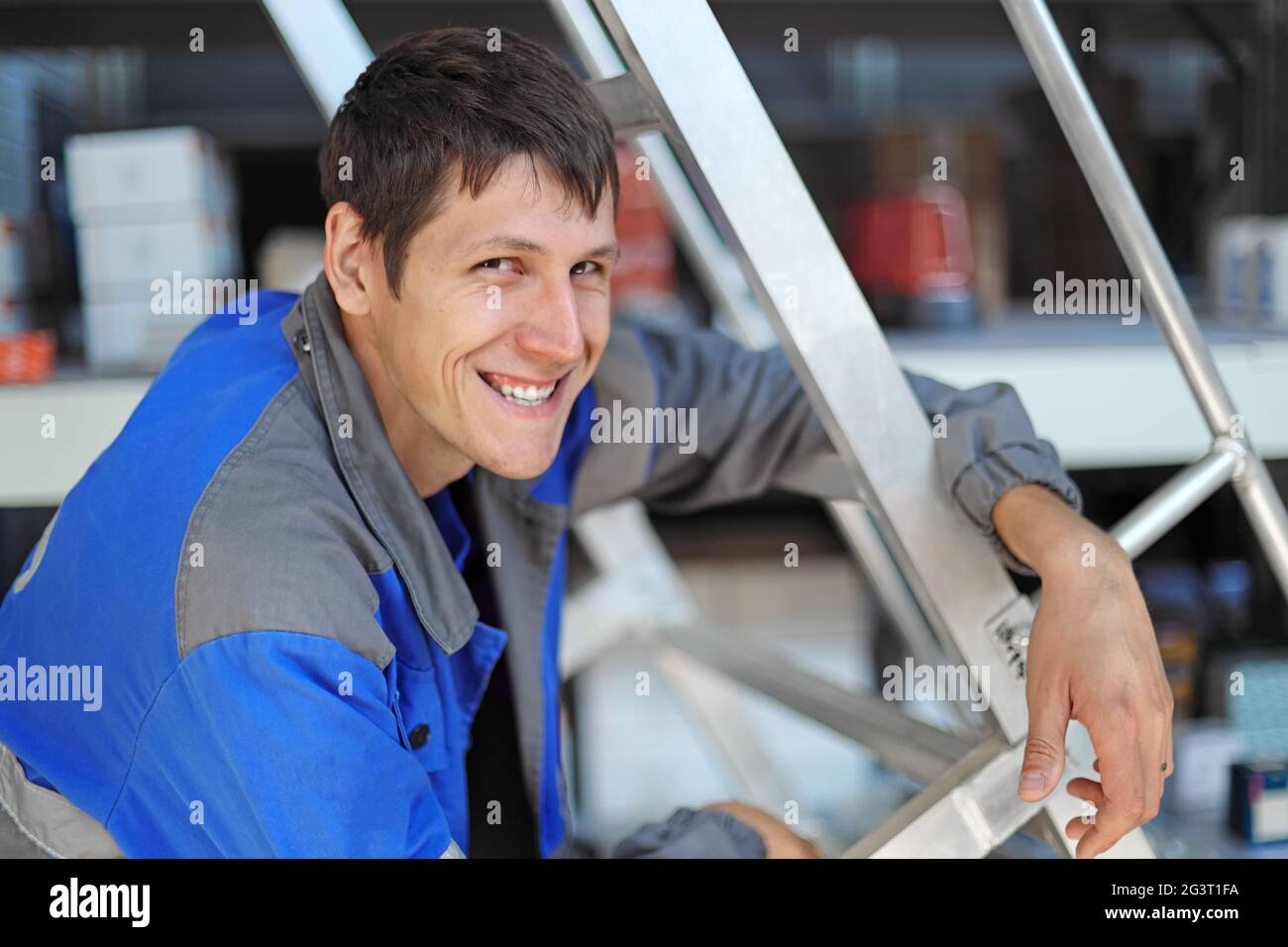 Ein fröhlicher und glücklicher Mitarbeiter lächelt am Arbeitsplatz. Positive junge Kerl von kaukasischen Auftritt in Stockfoto