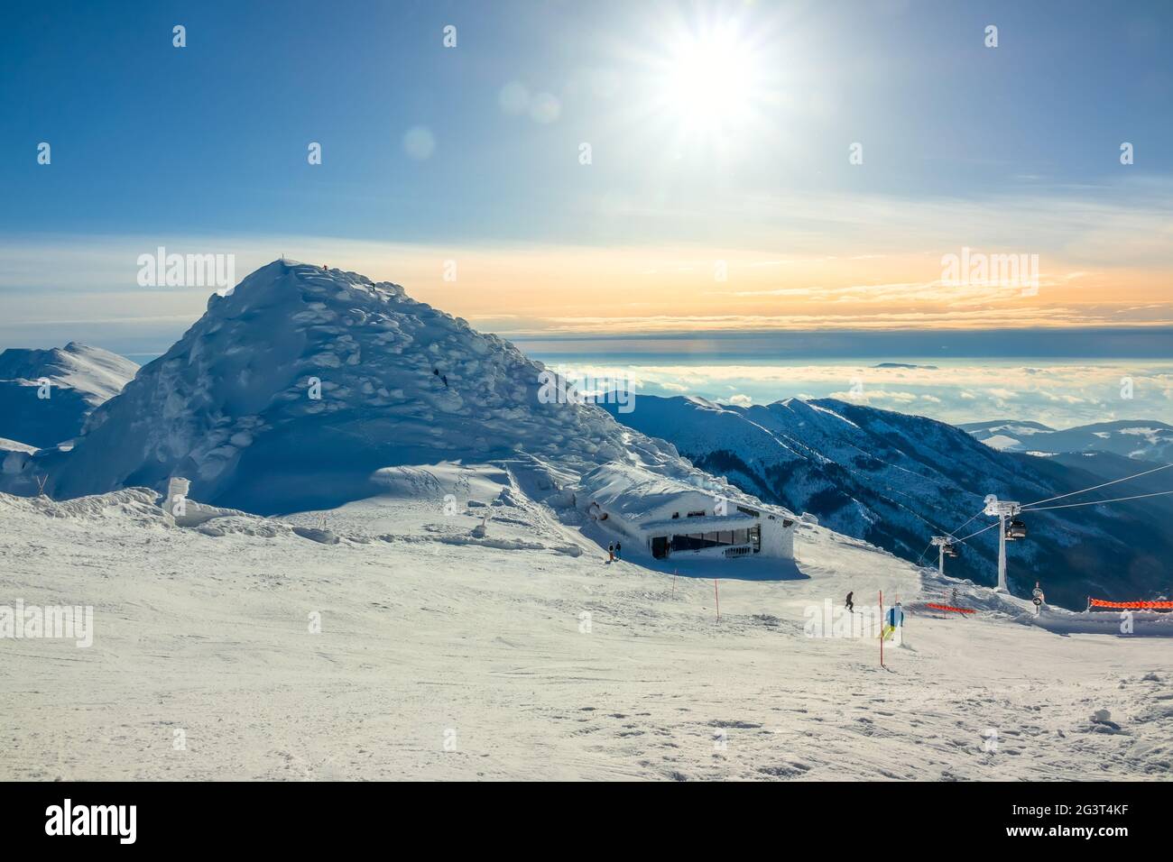 Wintersonne über den Gipfeln und Ski Bar Stockfoto