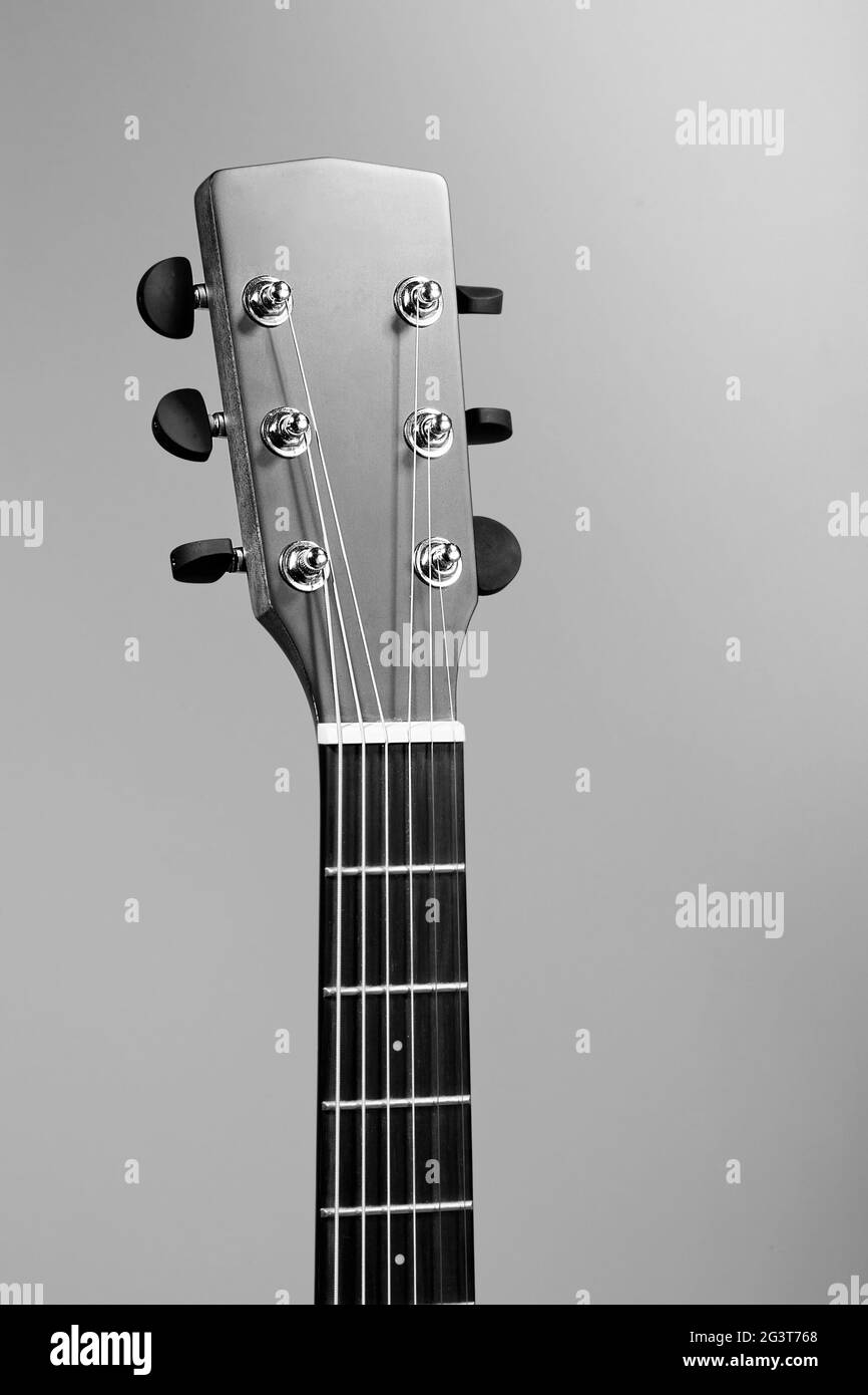 Das Griffbrett einer akustischen Gitarre aus der Nähe. Studiofoto eines Musikinstruments. Modell Stockfoto