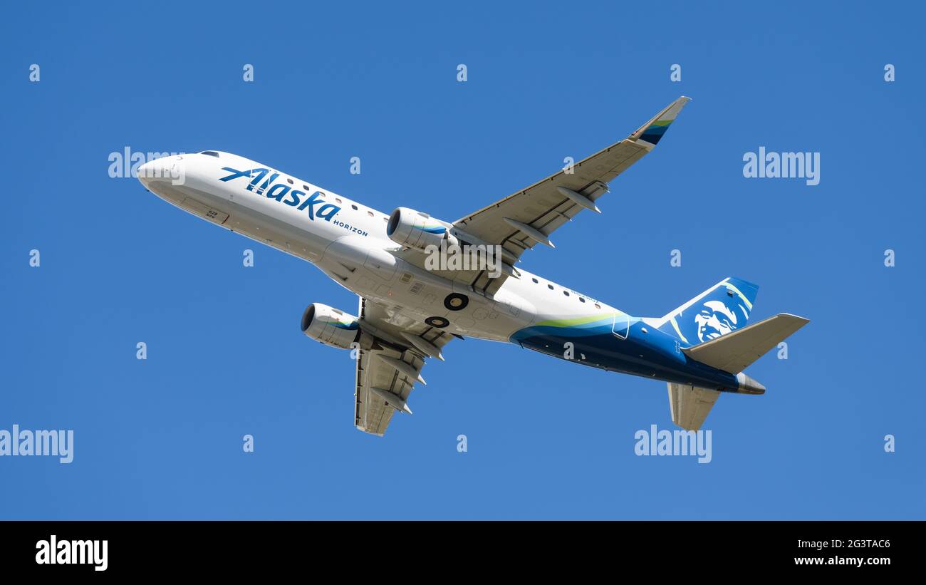 Everett, WA, USA - 16. Juni 2021; ein Alaska Horizon Embraer ERJ 170, der vom Snohomish County Airport gegen einen blauen Himmel klettert. Stockfoto
