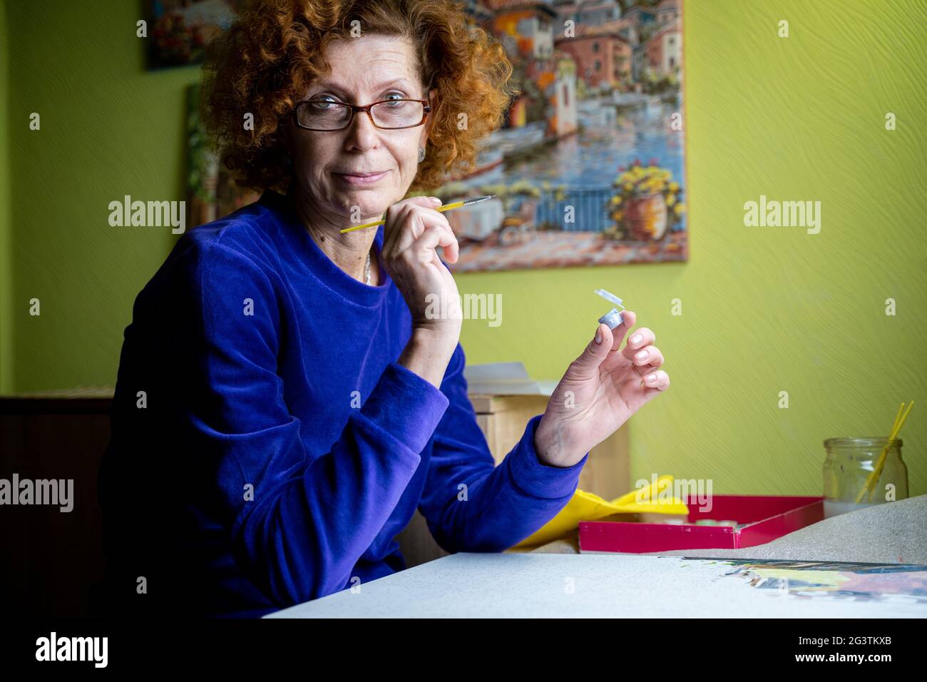 Alter, Ruhestand, Kreativität, Phantasie und Kunst. Kreatives Arbeiten. Kaukasische reife weibliche Farben Bild auf Leinwand mit Ölfarbe Stockfoto