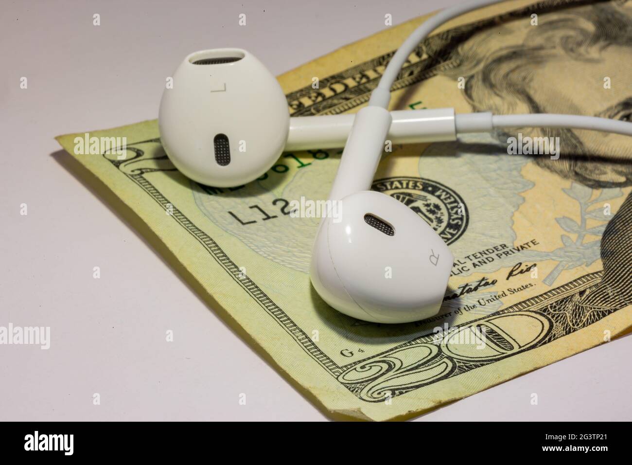 Kopfhörer zusätzlich zum Geld, das Sie symbolisiert, können Sie mehr verdienen, indem Sie wertvolles Material hören Stockfoto
