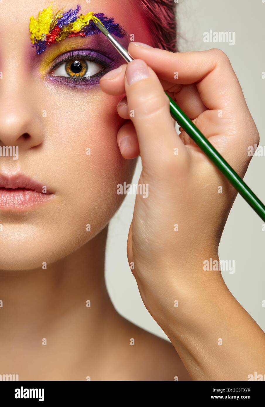 Künstler Hand mit Pinsel Malerei schöne Mädchen Brauen Make-up. Stockfoto