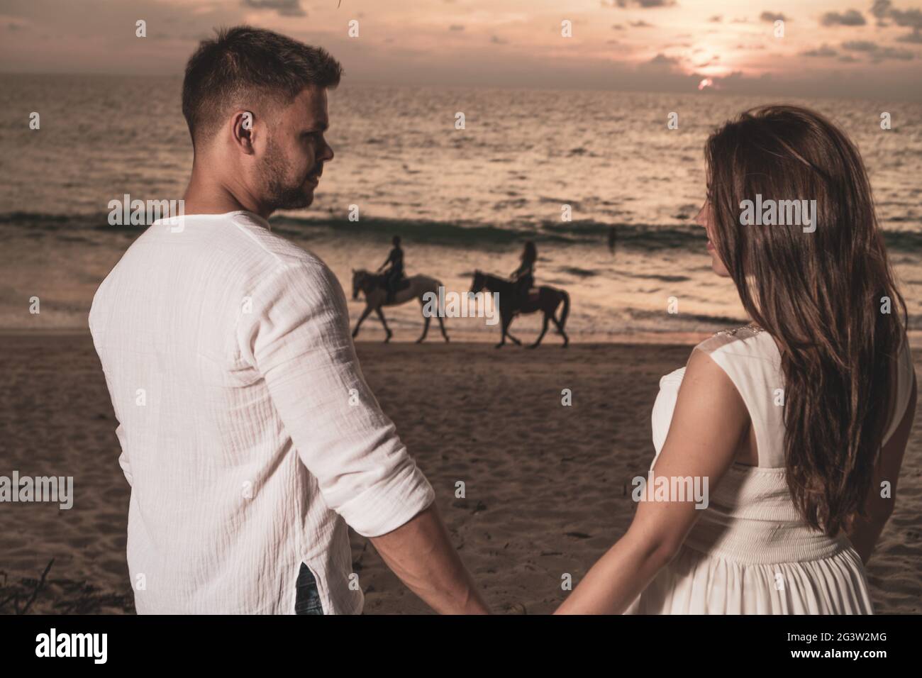 Romantisches Paar am Strand während des Sonnenuntergangs Stockfoto