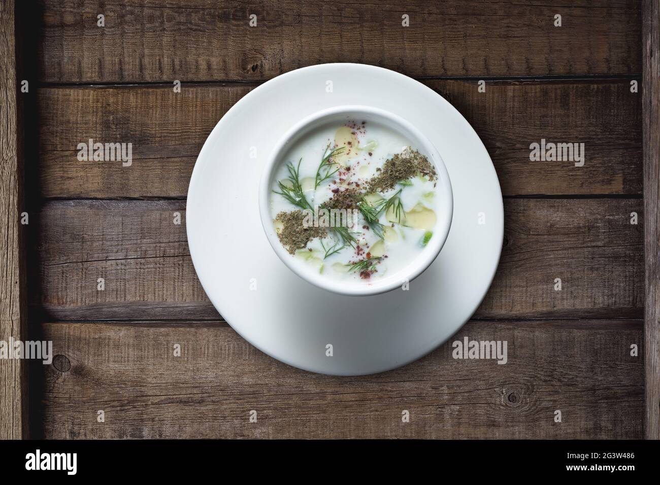 Türkische Yayla- oder Joghurtsuppe mit Minzsauce (Tzatziki) auf rustikalem Holztisch Stockfoto