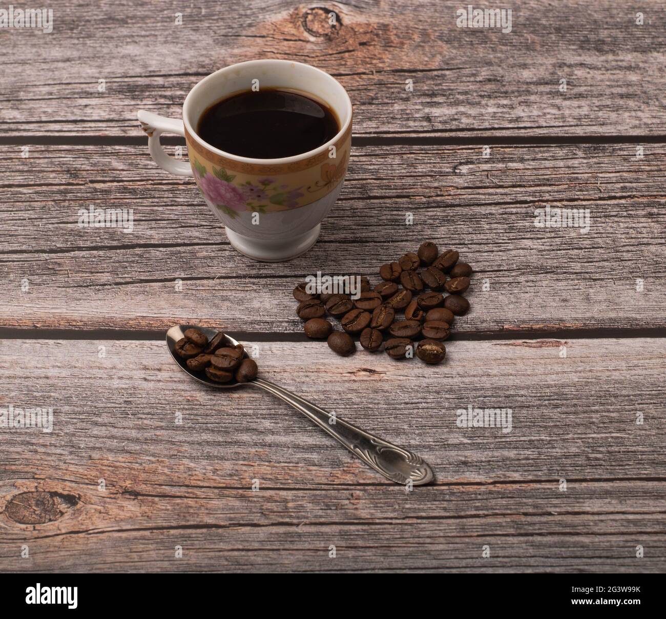 Dunkler Kaffee und Körner auf Holzhintergrund Stockfoto