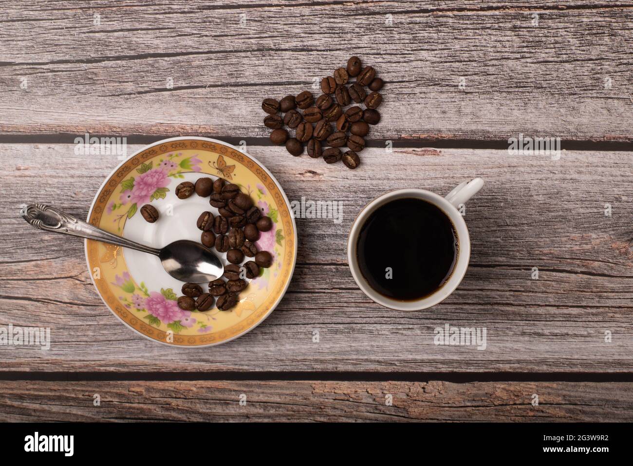 Dunkler Kaffee und Körner auf Holzhintergrund Stockfoto
