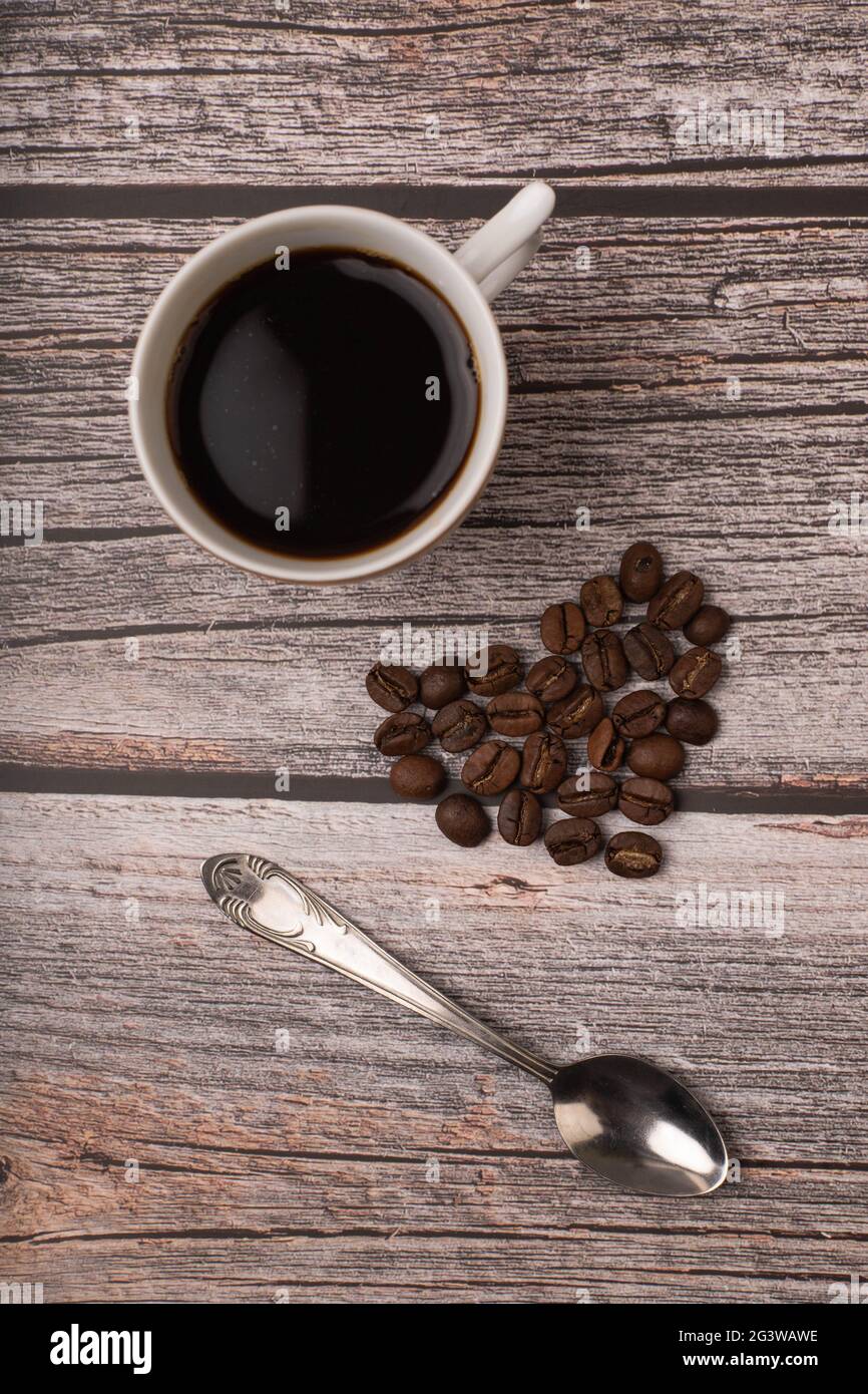 Dunkler Kaffee und Körner auf Holzhintergrund Stockfoto