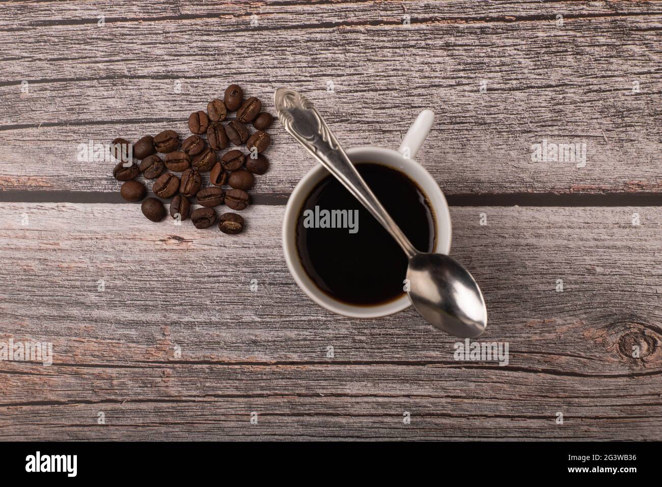 Dunkler Kaffee und Körner auf Holzhintergrund Stockfoto