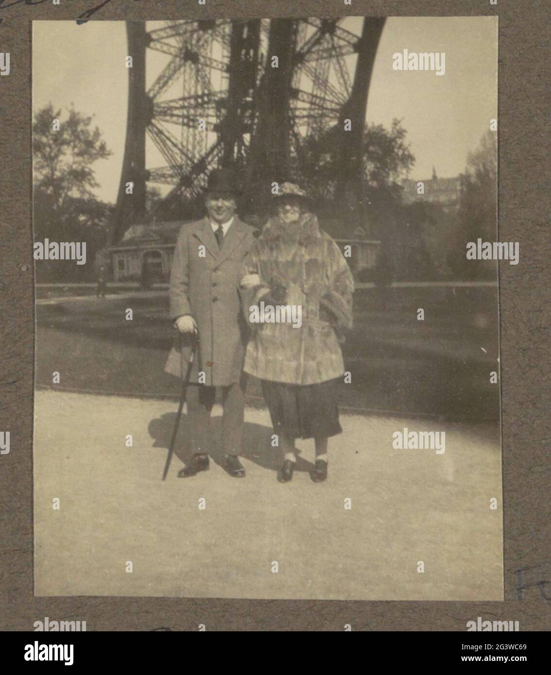 Mann und Frau unter dem Eiffelturm in Paris; wahr? Unter dem Eifelturm! Teil des Fotoalbums einer unbekannten holländischen Familie mit Aufnahmen von Suriname, Europa und Niederländisch-Ostindien. Stockfoto