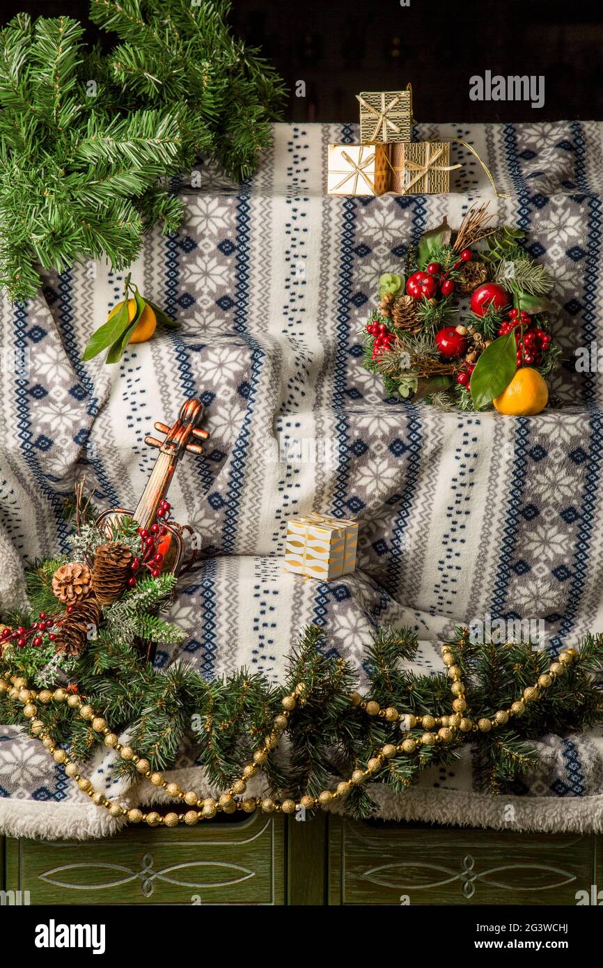 Winter Weihnachten Hintergrund für Design. Gemusterter, warmer Bettüberwürfe, handgestrickt. Weihnachtsschmuck, Girlande, Fichtenzweige. Stockfoto