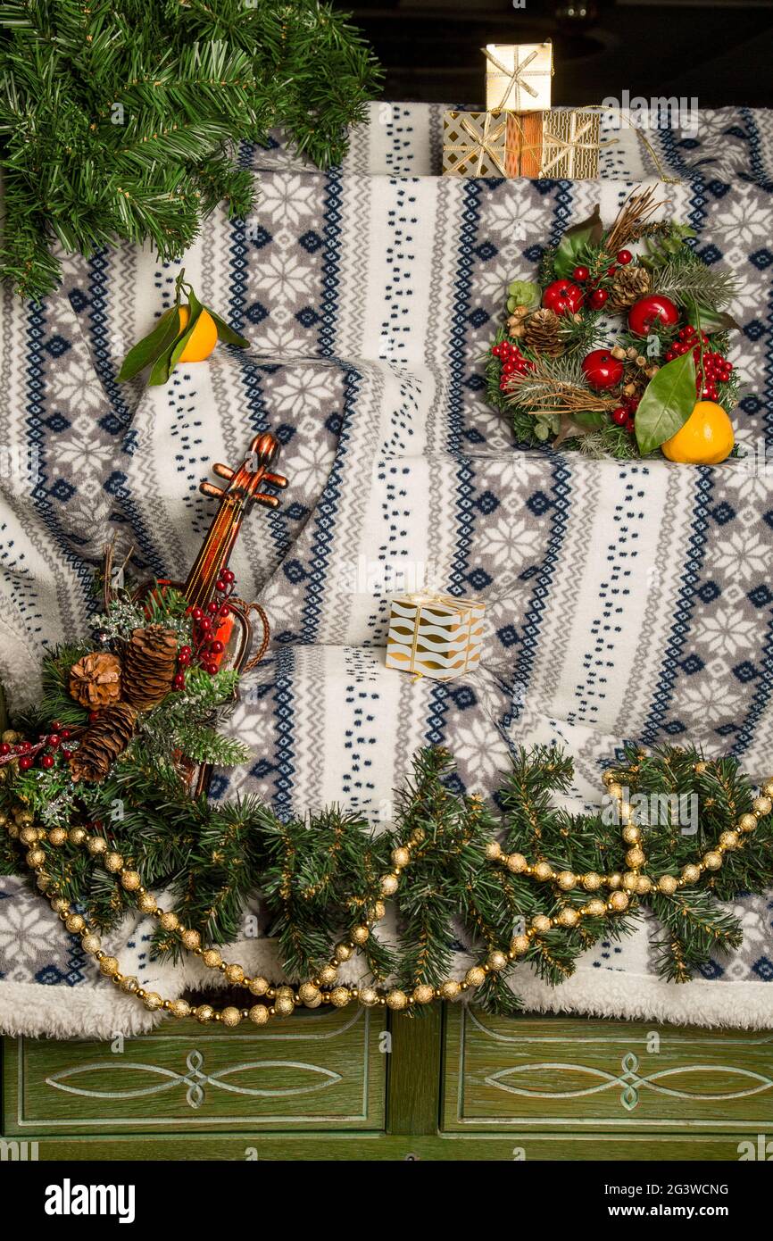 Winter Weihnachten Hintergrund für Design. Gemusterter, warmer Bettüberwürfe, handgestrickt. Weihnachtsschmuck, Girlande, Fichtenzweige. Stockfoto