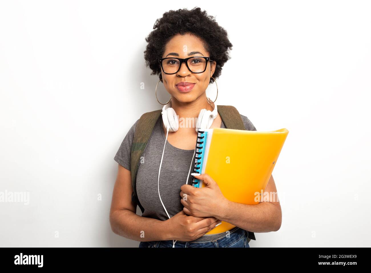 Porträt einer lächelnden afrikanischen Studentin, die Lehrbücher in der Hand hält. Stockfoto
