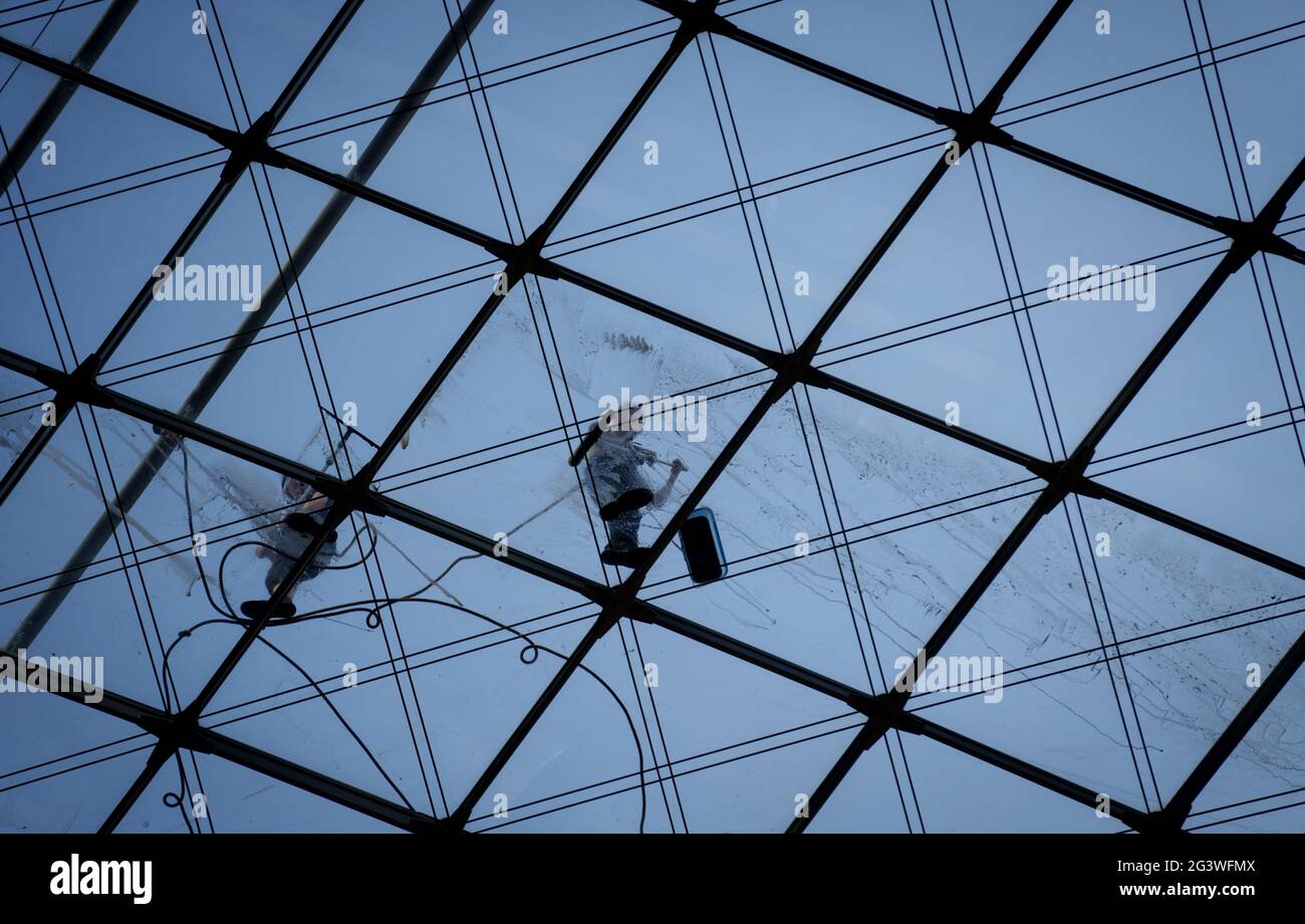 Berlin, Deutschland. Juni 2021. Das Glasdach des Berliner Hauptbahnhofs wird bei Hochsommertemperaturen am frühen Morgen von Fensterputzern gereinigt. Quelle: Kay Nietfeld/dpa/Alamy Live News Stockfoto