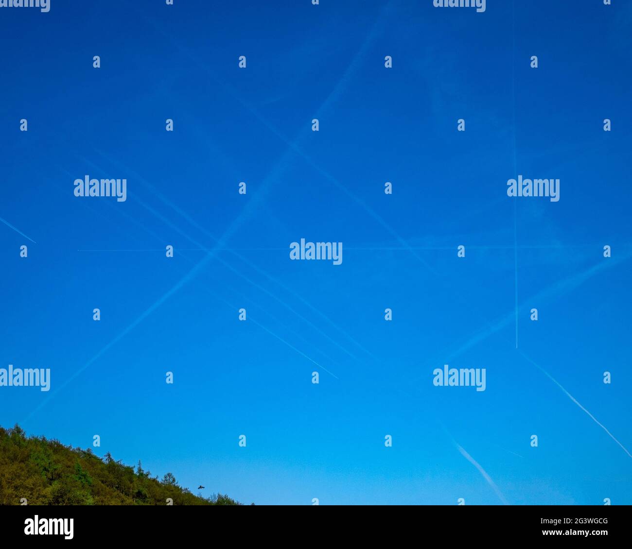 Großer Flugverkehr am Himmel - die Gleise des Flugzeugs machen einen rechten Winkel Stockfoto