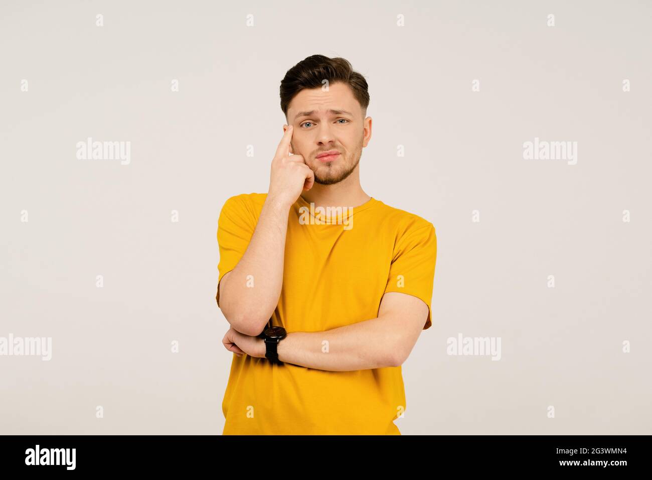 Verwirrung oder Enttäuschung, Facepalm schöner junger Mann auf seinem Gesicht. Junge Casual Mann in gelbem T-Shirt Porträt isoliert auf wh Stockfoto