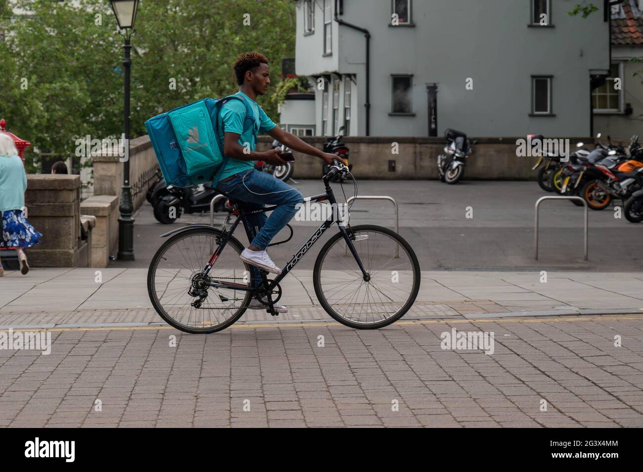 Deliveroo Food Courier, der durch das Stadtzentrum von Norwich radelt Stockfoto