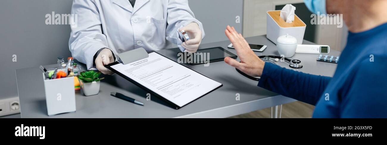 Patient, der den vom Arzt angebotenen Coronavirus-Impfstoff ablehnt Stockfoto