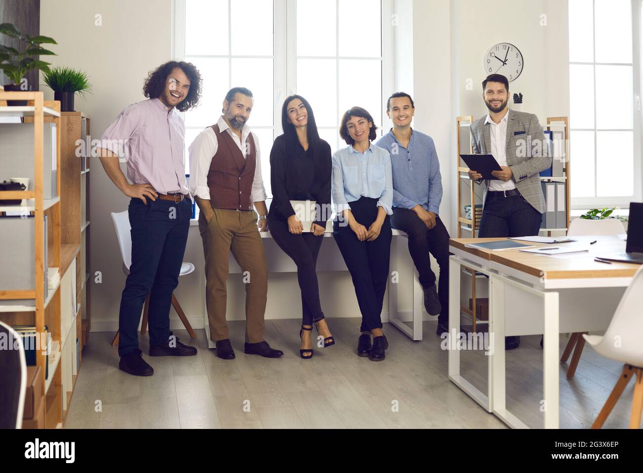 Erfolgreiches kreatives professionelles Business-Team steht am Fenster im modernen Büro Stockfoto