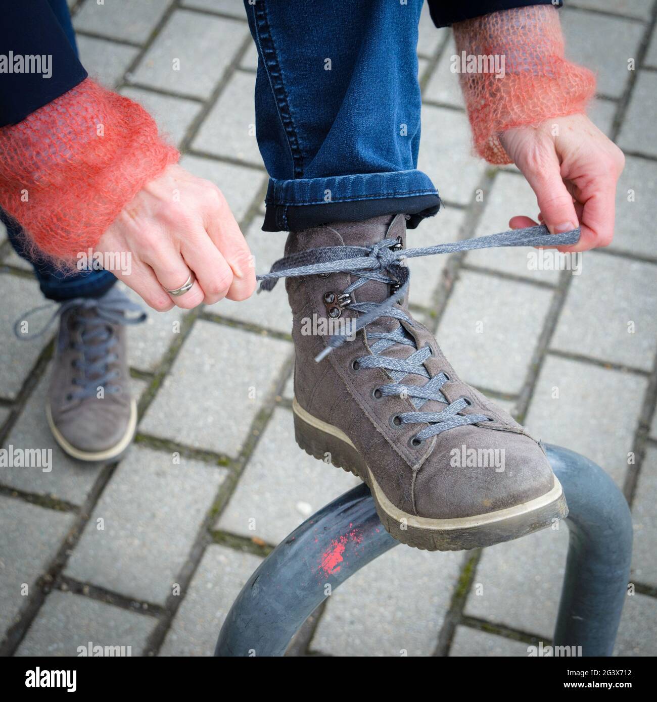 Frau schnürt ihre Turnschuhe Stockfoto