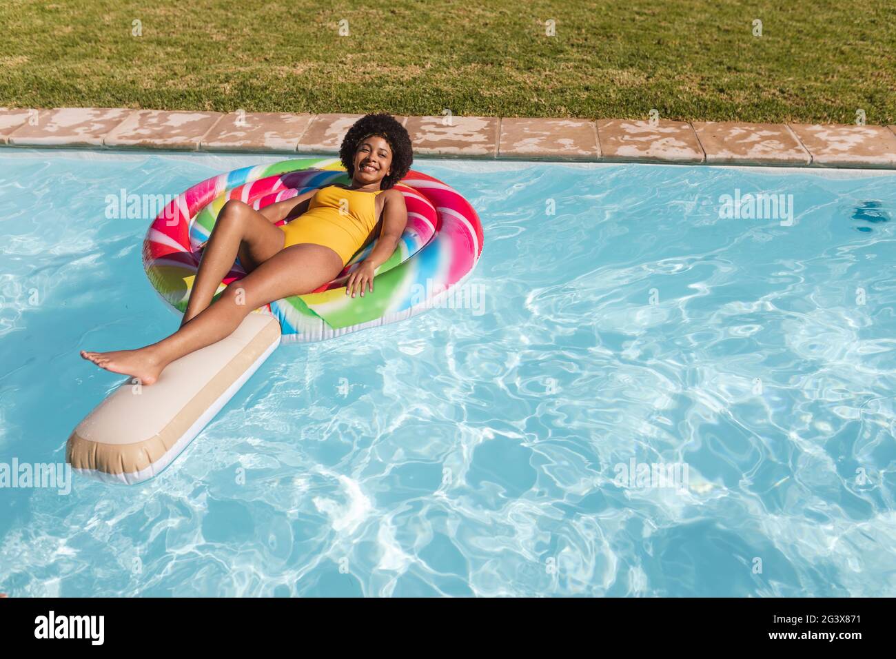 Gemischte Rennen Frau mit Spaß spielen auf aufblasbaren im Schwimmbad Stockfoto