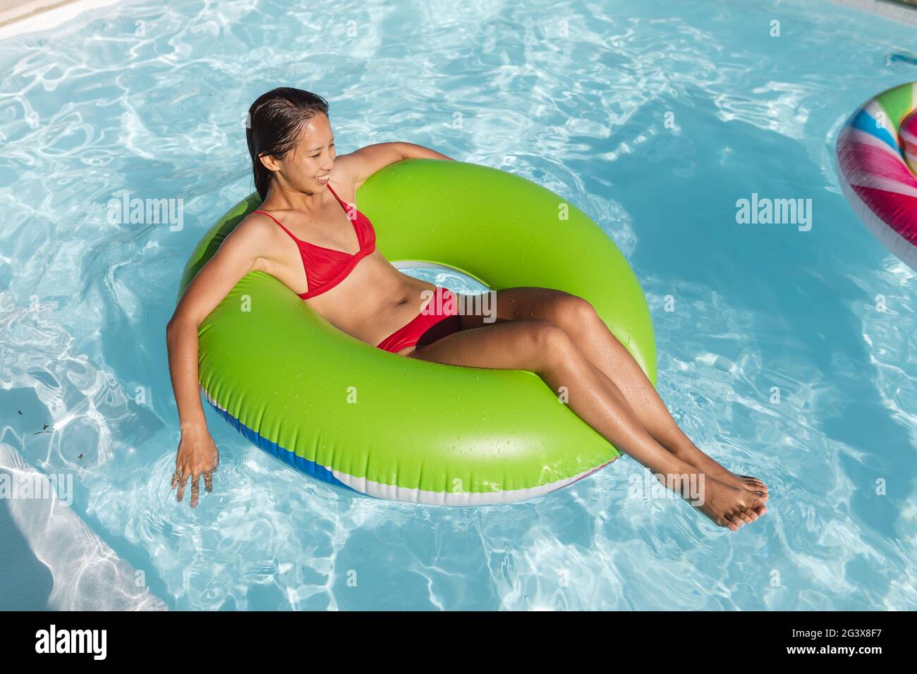 Gemischte Rennen Frau mit Spaß spielen auf aufblasbaren im Schwimmbad Stockfoto