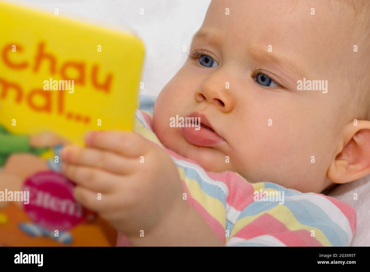 Baby schaut sich ein Buch an Stockfoto