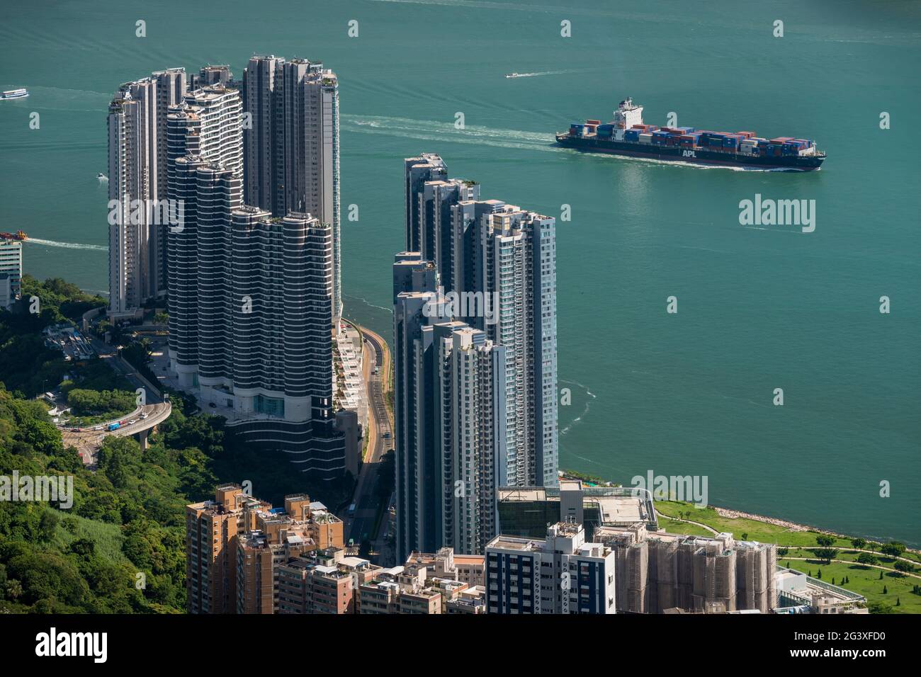 Ein Schiff im East Lamma Channel dampft an den luxuriösen Hochhäusern der Residence Bel-air in Pok Fu Lam, Hong Kong Island vorbei Stockfoto