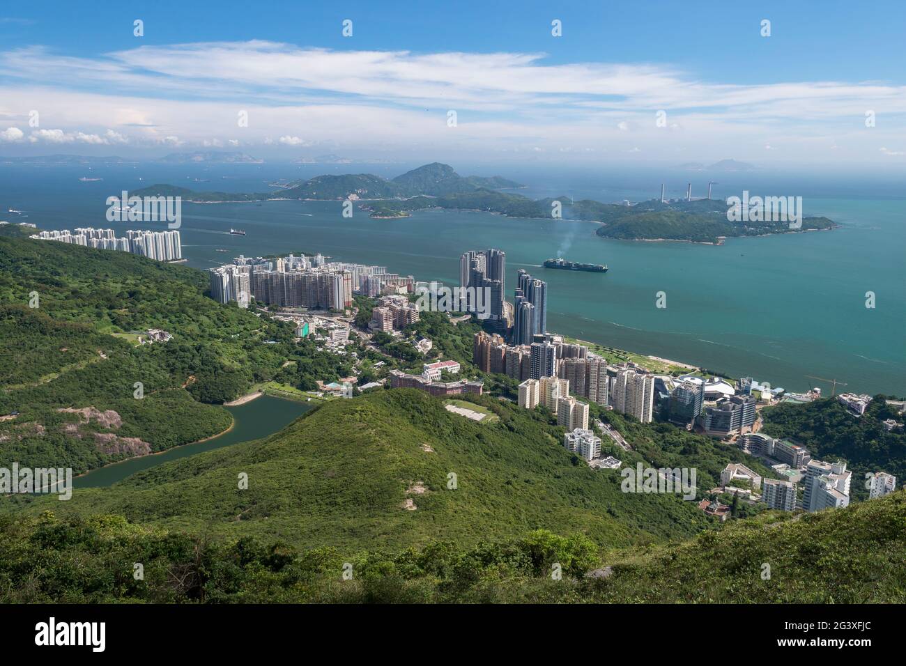 Schiffe im East Lamma Channel laufen am Tech-Hub Cyberport und den Hochhäusern von Pok Fu Lam, Hong Kong Island, vorbei Stockfoto