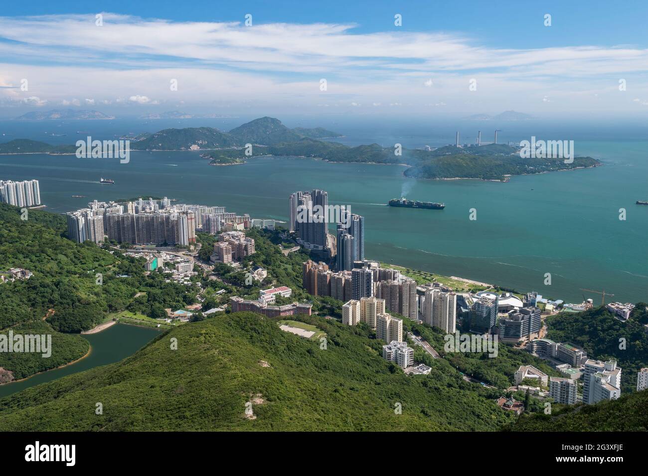 Schiffe im East Lamma Channel laufen am Tech-Hub Cyberport und den Hochhäusern von Pok Fu Lam, Hong Kong Island, vorbei Stockfoto