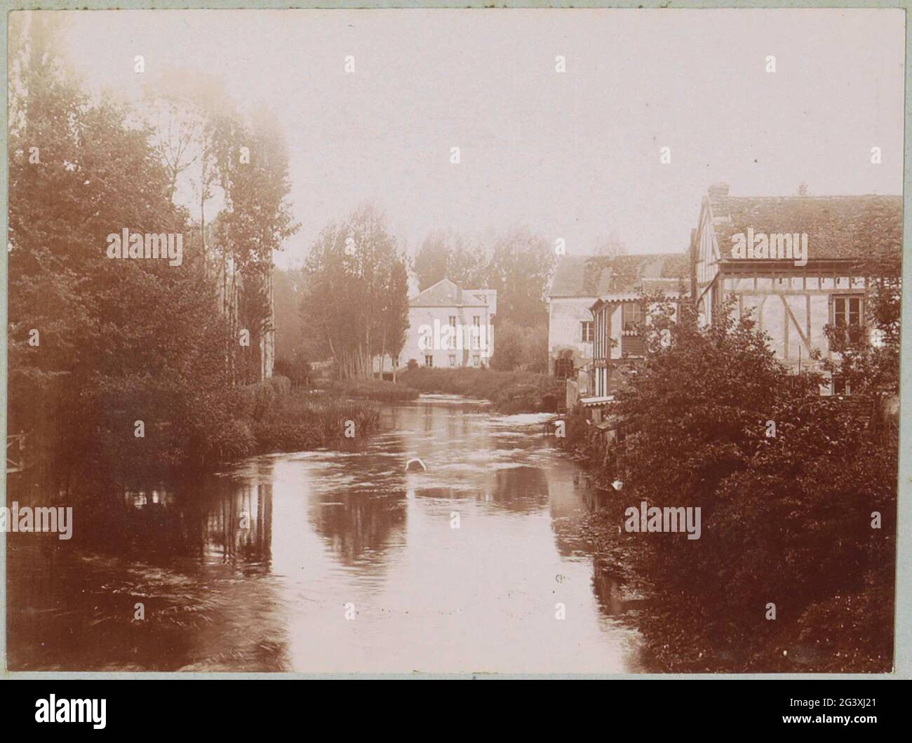 Häuser auf einem Wasser in Pacy-sur-Eure. Teil des Fotoalbums eines französischen Amateurfotografen mit Aufnahmen von Reisen in Frankreich, Spanien, Belgien, Luxemburg und den Niederlanden, den ersten Automobilen und Autorassen. Stockfoto